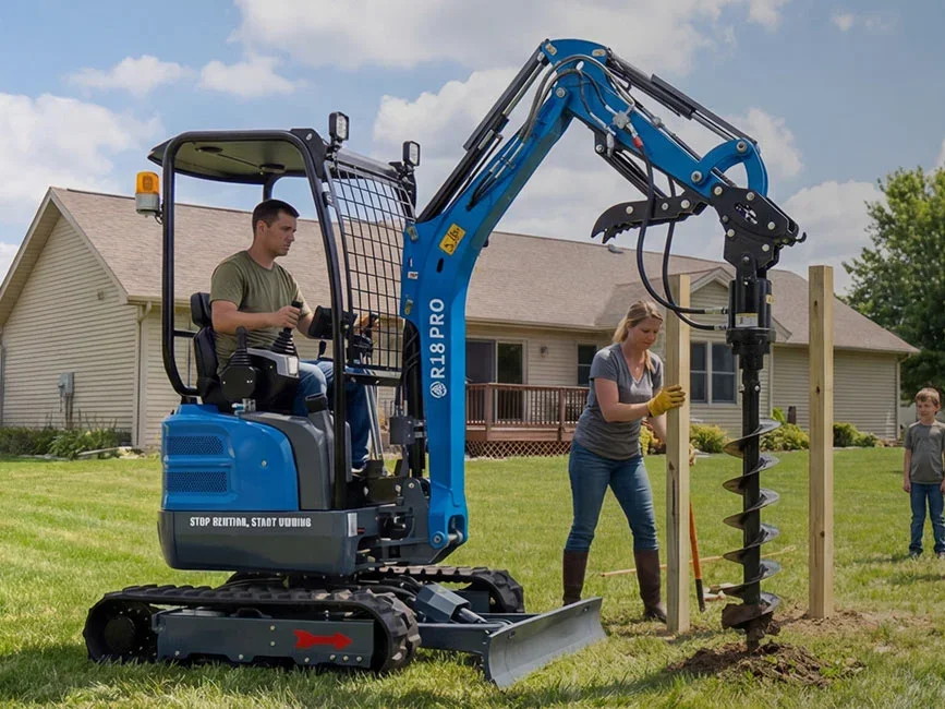 Operator using a blue Rippa R18 PRO mini excavator with an auger attachment to dig post holes in a residential yard