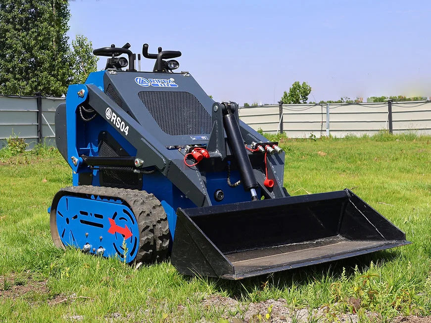 Blue Rippa RS04 mini skid steer loader with bucket attachment, parked on grass